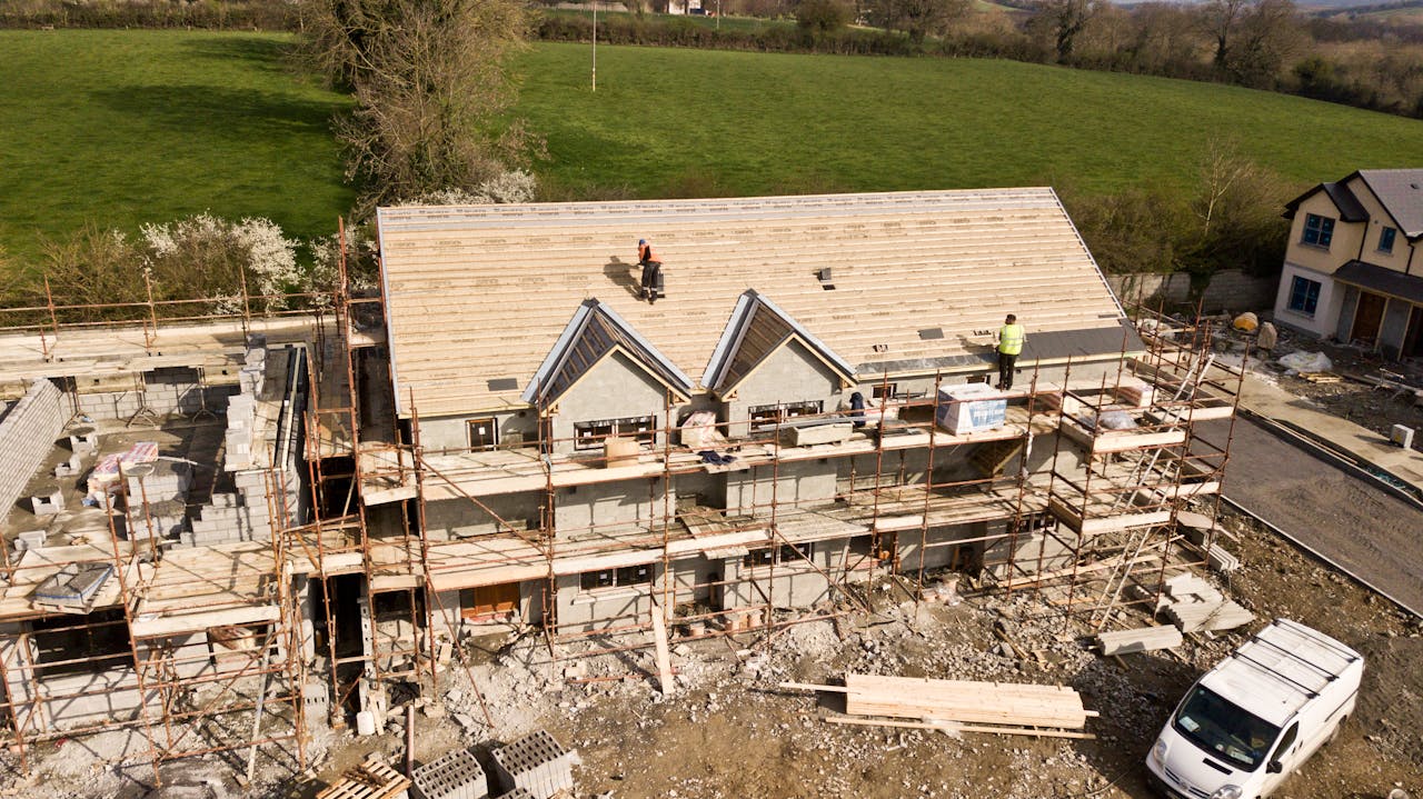 why-choose-us Aerial shot of a house under construction in Clonmel, Ireland. Workers on the roof.